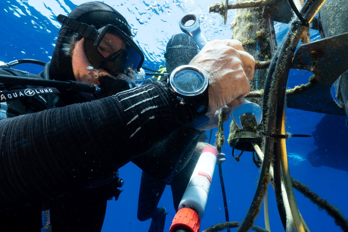 Person using measuring tools under water.