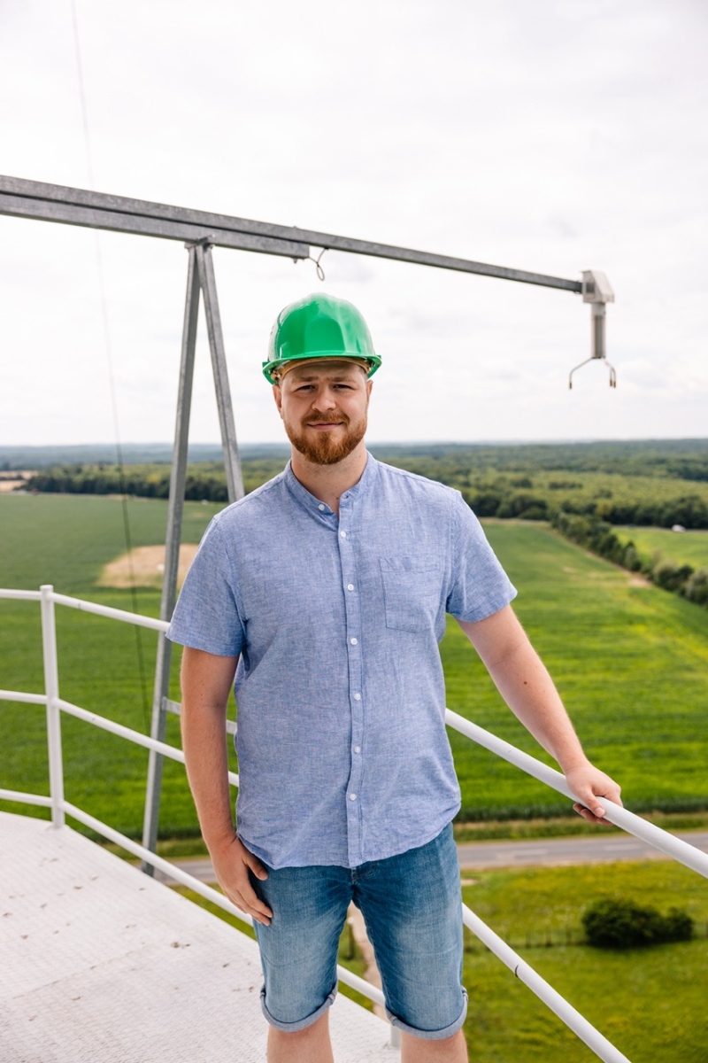 portrait of a young scientist standing next to a measurement instrument