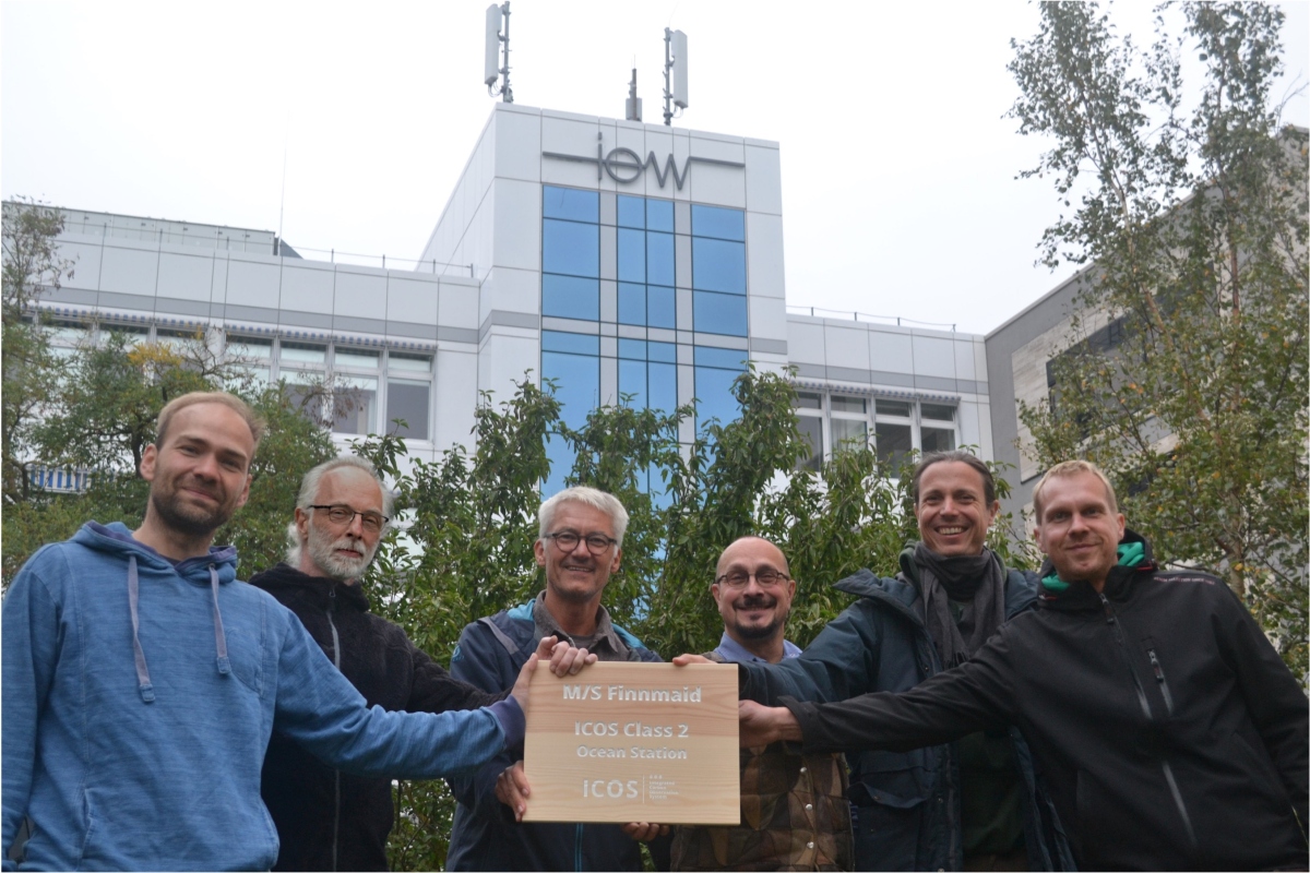 Group picture of scientist of IOW holding a wooden sign of the ICOS label