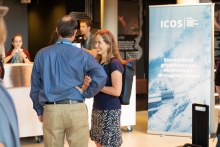 scientists interacting in front of an ICOS roll up 